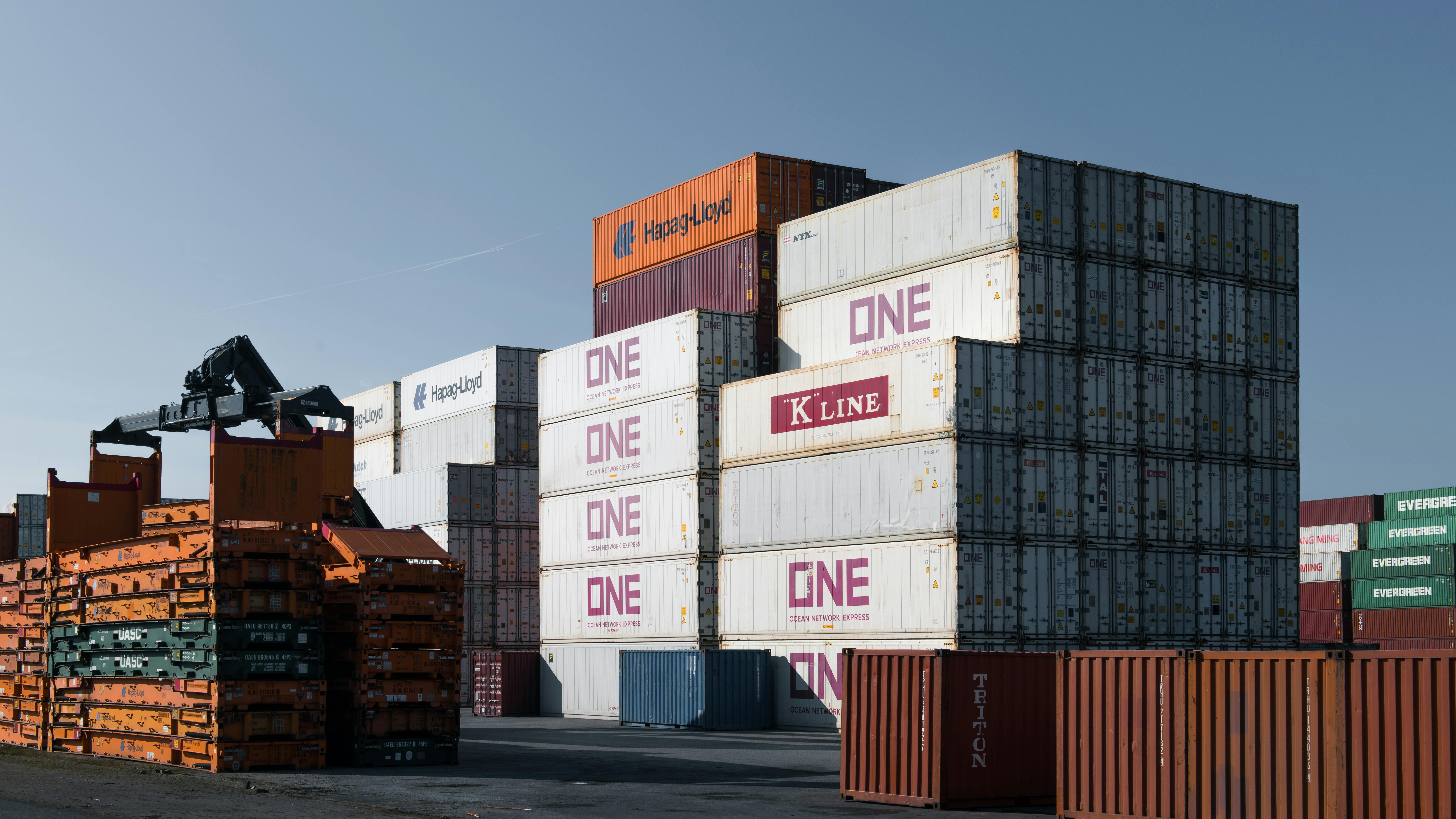 Navă cargo în port cu containere colorate și macarale — operațiuni portuare Constanța